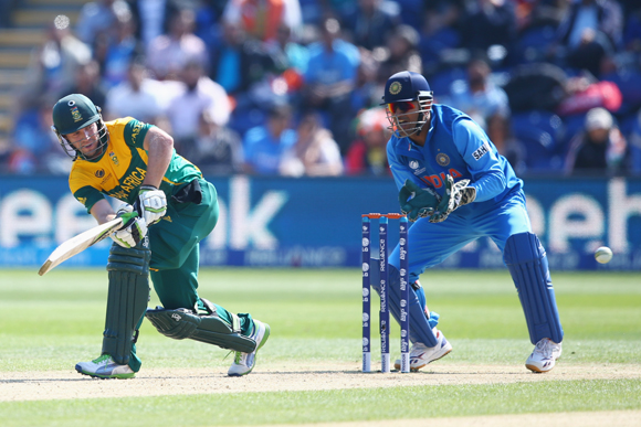 AB de Villiers (L) of South Africa plays to the legside as wicketkeeper MS Dhoni (R) of India looks on