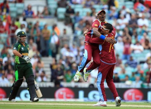 Sunil Narine is congratulated by Dwyane Bravo after he takes the wicket of Kamran Akmal