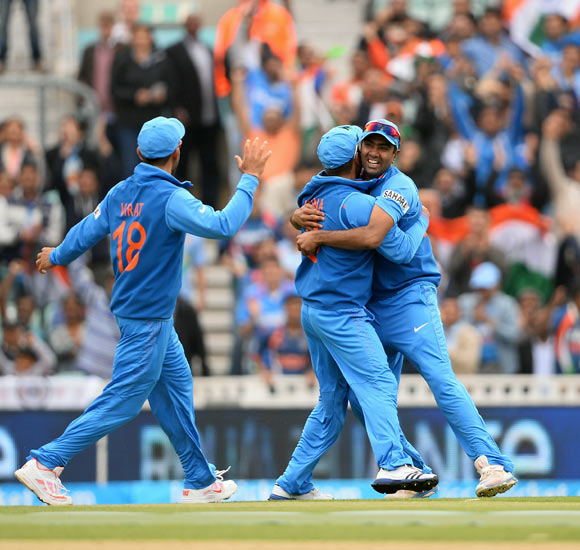 Ravichandran Ashwin (right) celebrates with team-mates after taking the catch to dismiss Chris Gayle