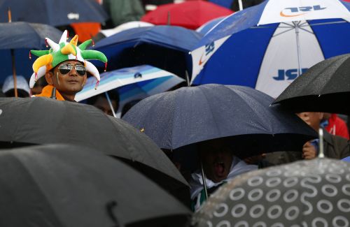 An India fan looks out from a bank of umbrellas as rain stops play during their ICC Champions Trophy group B match against Pakistan at Edgbaston cricket ground