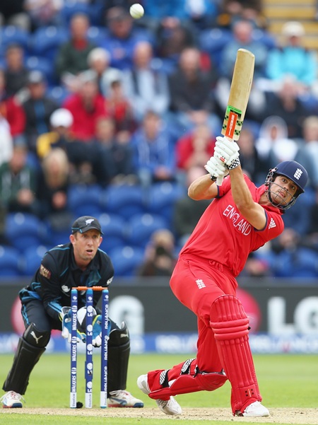 Alastair Cook (right) of England hits to the off side as Luke Ronchi (left) of New Zealand looks on