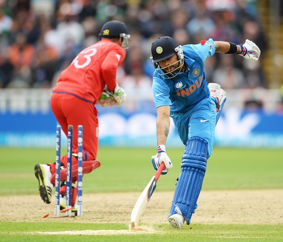 Virat Kohli of India stretches to make his ground