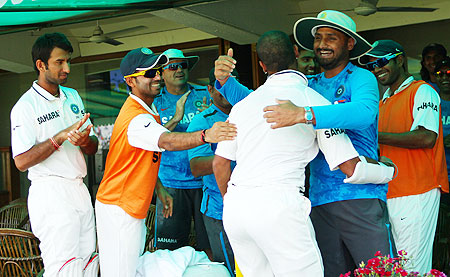Shikhar Dhawan (right) is congratulated by teammates in the dressing room after scoring a century on debut on Saturday