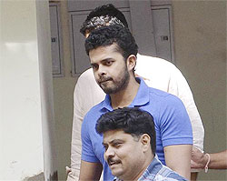 Former test bowler Shanthakumaran Sreesanth is taken to a court by police personnel in New Delhi
