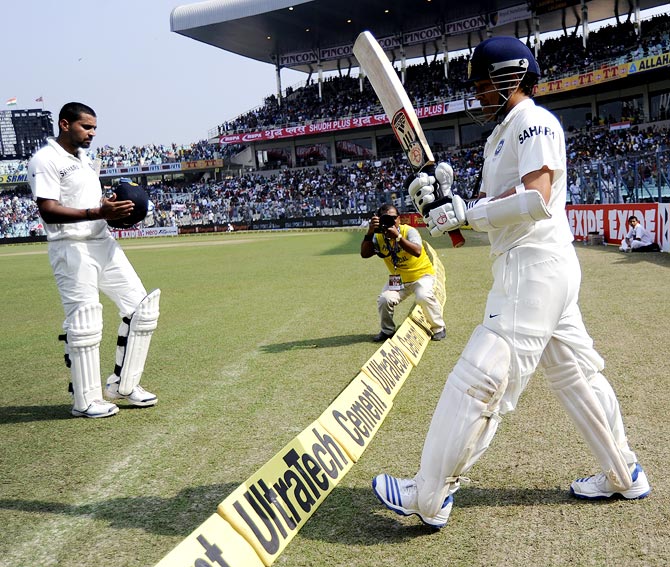 Sachin Tendulkar walks out to bat as Murali Vijay heads to the pavilion after his dismissal