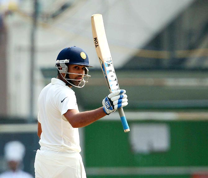 Rohit Sharma raises his bat after completing his fifty