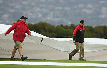Groundstaff cover the pitch at the Bellrive Oval on Friday