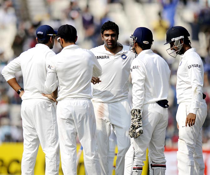 R Ashwin celebrates with his team mates after taking the wicket of Kieran Powell