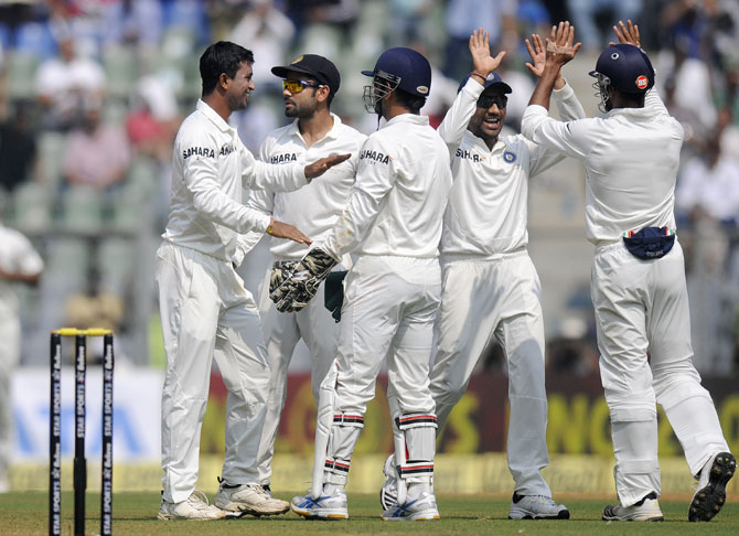Pragyan Ojha of India celebrates the wicket of Kieran Powell