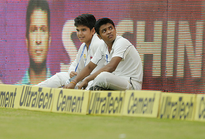 Arjun Tendulkar (left) does ball boy duty during Day 2 of the Test match at the Wankhede in Mumbai on Friday