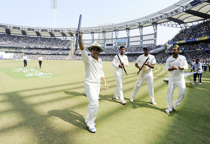 Team India stand guard of honour as Sachin Tendulkar of India waves to the crowd at the end of the match