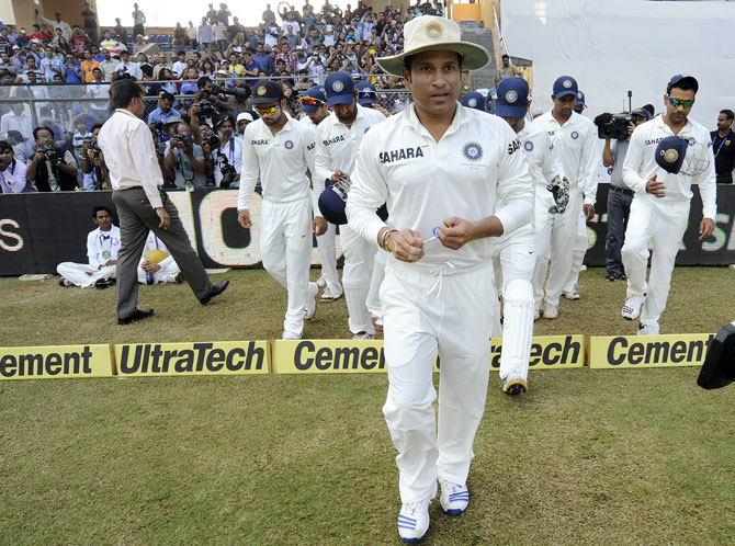 Sachin Tendulkar of India and Mahendra Singh Dhoni captain of India walk to field during day three