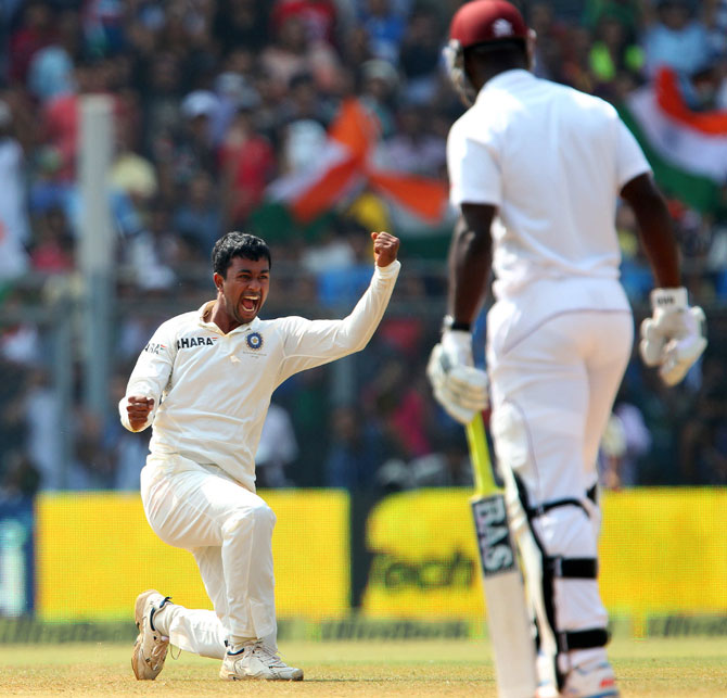  Pragyan Ojha of India celebrates the wicket of Darren Sammy