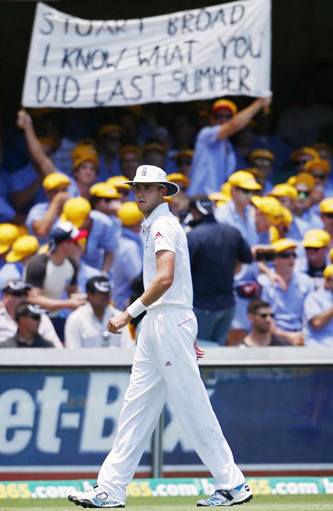 England's Stuart Broad stands in the outfield in front of a spectator's sign about him