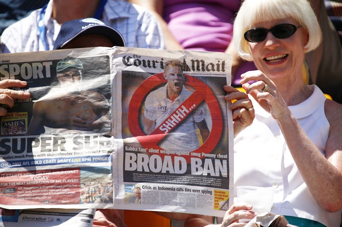 A member of the crowd holds up an anti-Stuart Broad newspaper front page