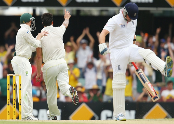 Mitchell Johnson of Australia celebrates taking the wicket of Graeme Swann of England