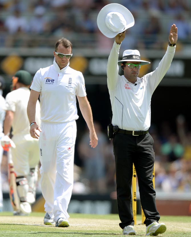 Graeme Swann walks back to his mark after being hit for six by Michael Clarke