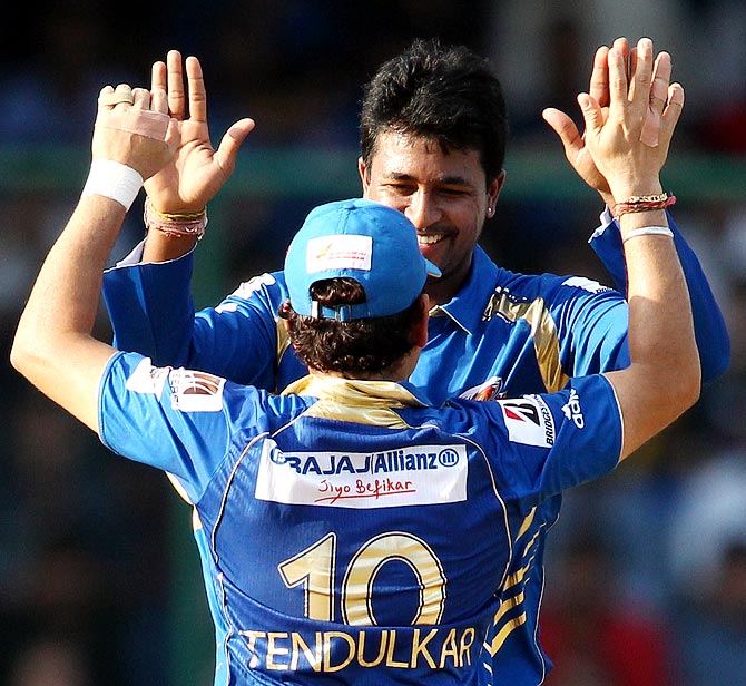 Pragyan Ojha celebrates with Sachin Tendulkar after taking the wicket of Simon Katich