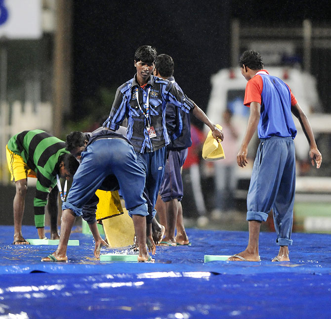 Workers collect water during the 4th ODI in Ranchi, which was abandoned due to rain. The 5th ODI in Cuttack, scheduled for Saturday, is set to face the same fate