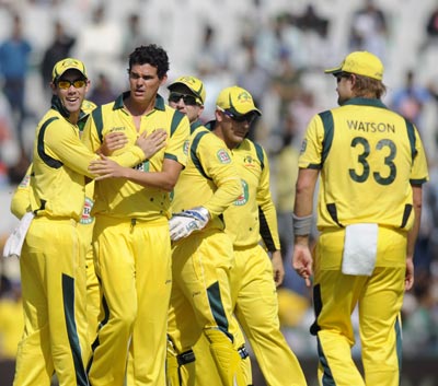The Australian team celebrates the fall of an Indian wicket