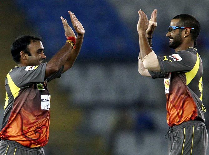 Amit Mishra is congratulated by captain Shikhar Dhawan after taking the wicket of Ali Waqas