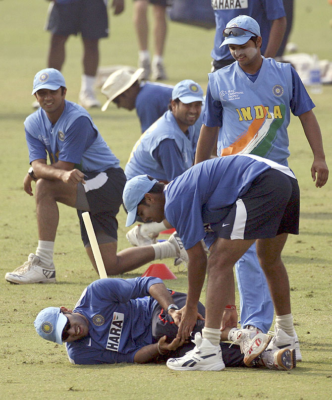 Indian players watch teammate Yuvraj Singh lying on the ground after he was injured during a training session during the ICC Champions trophy cricket tournament in Mohali on October 28, 2006
