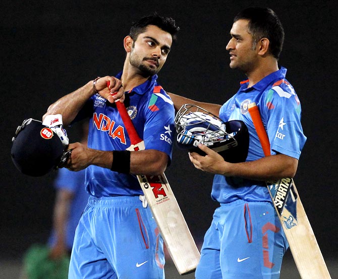 Virat Kohli (left) and Mahendra Singh Dhoni walk back at the end of India's innings in Sunday's final.