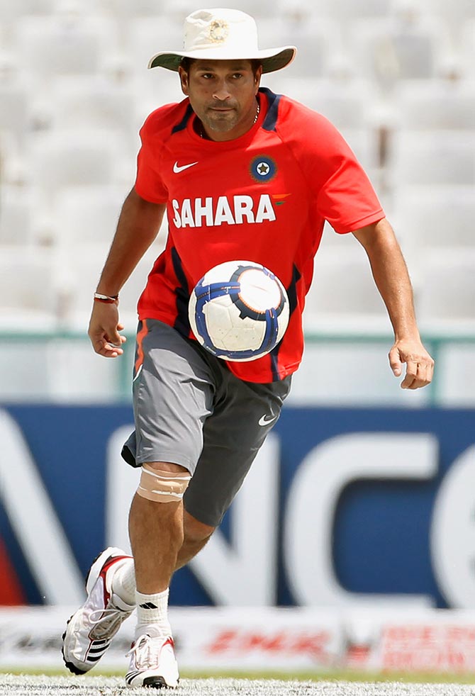 Sachin Tendulkar plays football during a training session