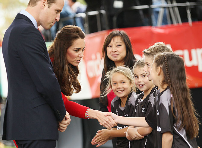 Kate Middleton shakes hands with young Henry Allott as Prince William watches Latimer Square on Monday