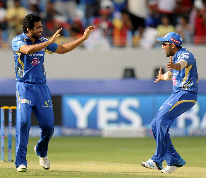 Zaheer Khan celebrates the wicket of Virat Kohli with captain Rohit Sharma (right)