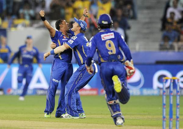 Pravin Tambe (left) is hugged by Shane Watson after taking the wicket of Mahendra Singh Dhoni