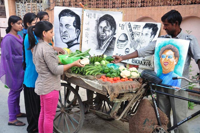 A vegetable seller with Sachin Tendulkar's portraits to celebrate his birthday in Moradabad
