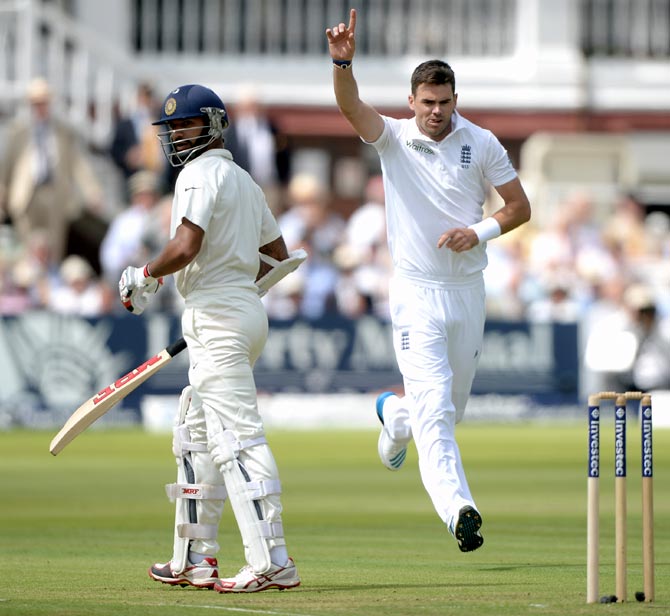 England fast bowler James Anderson (right) celebrates as Shikhar Dhawan walks after his dismissal during day one of the second Test match at Lord's