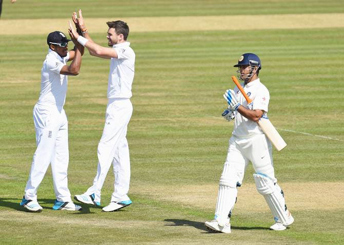 James Anderson (right) is congratulated by Chris Jordan after taking the wicket of Mahendra Singh Dhoni