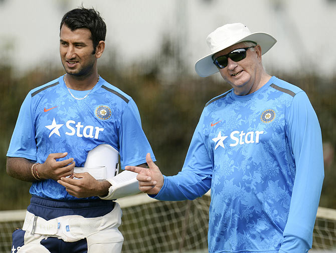 India's Cheteshwar Pujara talks to coach Duncan Fletcher (right) during a training session on Tuesday