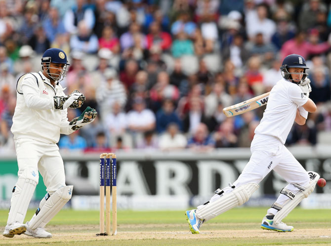 Joe Root cuts a ball to pick up some runs, watched by India wicketkeeper Mahendra Singh Dhoni