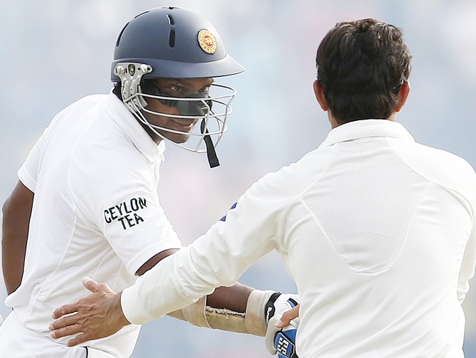 Sri Lanka's Kumar Sangakkara, left, is congratulated by Pakistan's Saeed Ajmal for his   double century during the fourth day of their first Test cricket match against Pakistan