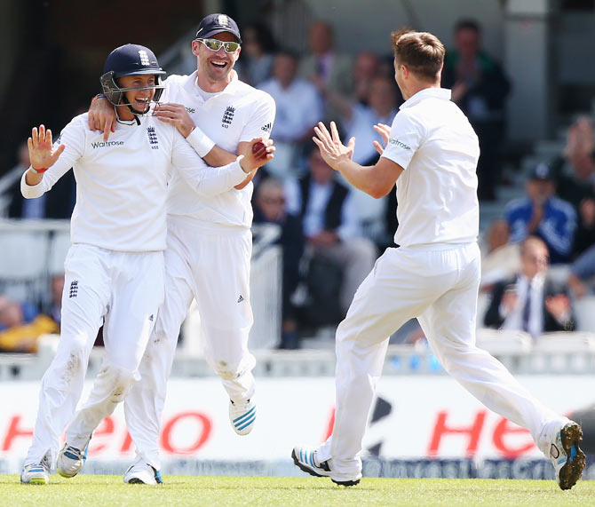 Joe Root of England (left) celebrates with James Anderson (centre) and Chris Woakes (right) after catching out Murali Vijay  on Friday