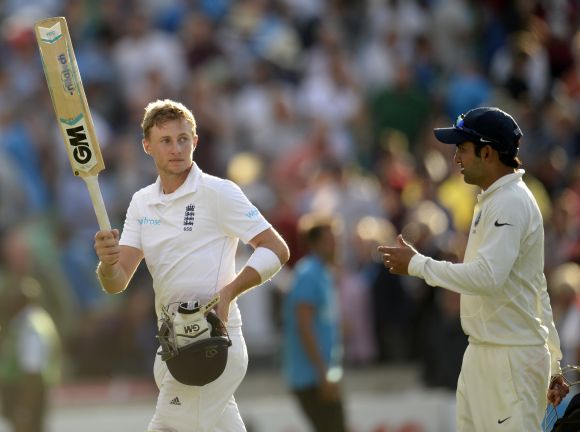 England's Joe Root (L) leaves the field on 92 not out with India's Gautam Gambhir during the fifth cricket Test match at the Oval cricket ground 
