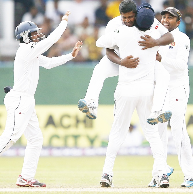 Sri Lanka's Rangana Herath (top) celebrates with captain Angelo Mathews, Mahela Jayawardene, right, and Kaushal Silva after taking the wicket of Pakistan's Asad Shafiq (not pictured)