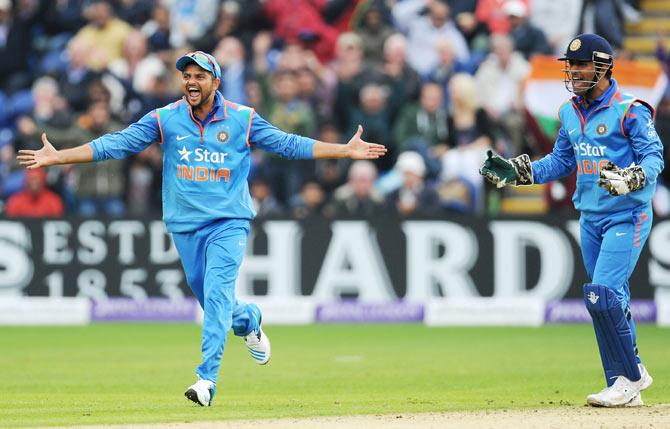 India fielders MS Dhoni (r) and Suresh Raina celebrate after India had dismissed Jos Buttler