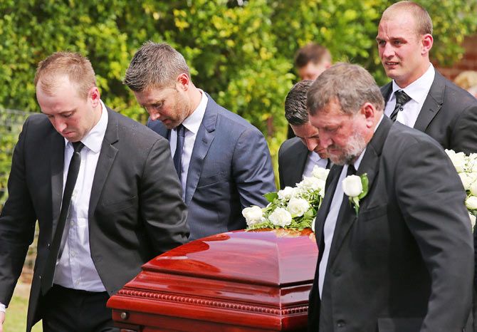 Australian cricket captain Michael Clarke helps Jason Hughes (left) and father Gregory Hughes (right) carry the coffin of Phillip Hughes on Wednesday