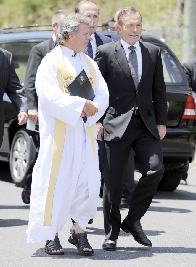 Prime Minister Tony Abbott is greeted by Father Michael Alcock upon arrival ahead of the Funeral Service for Phillip Hughes