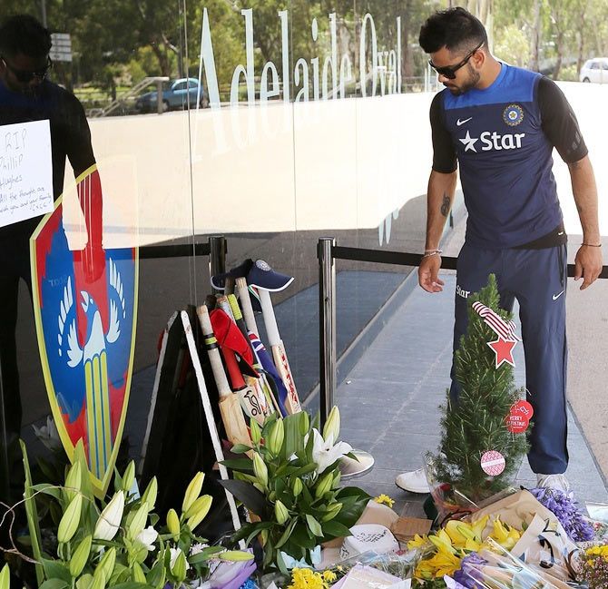 Virat Kohli of India leaves a bat and cap at a memorial for Phil Hughes outside the Adelaide Oval