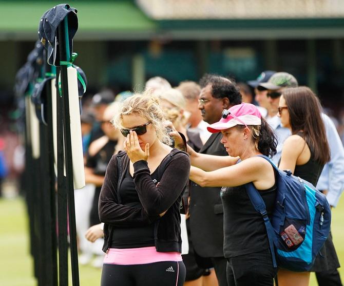 Mourners pay their respects as people gather to watch the funeral service held in Macksville for Australian cricketer Phillip Hughes