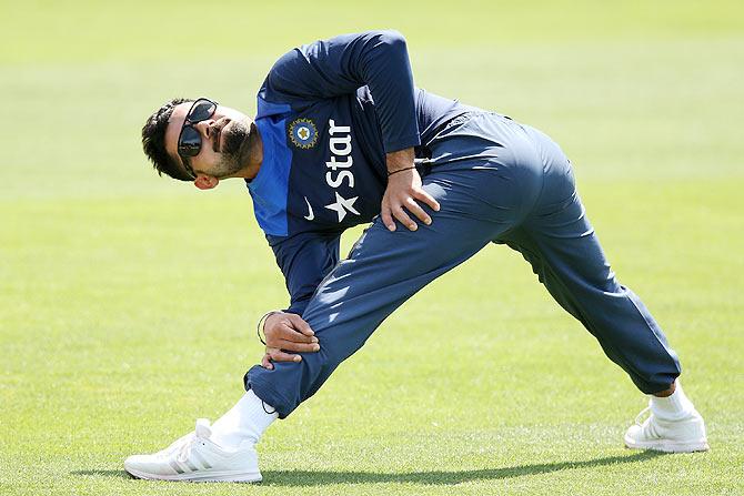 Virat Kohli stretches during a training session 