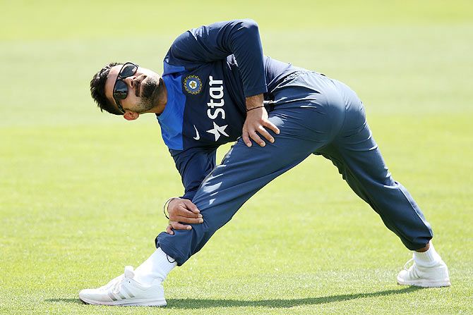 Virat Kohli stretches during a training session