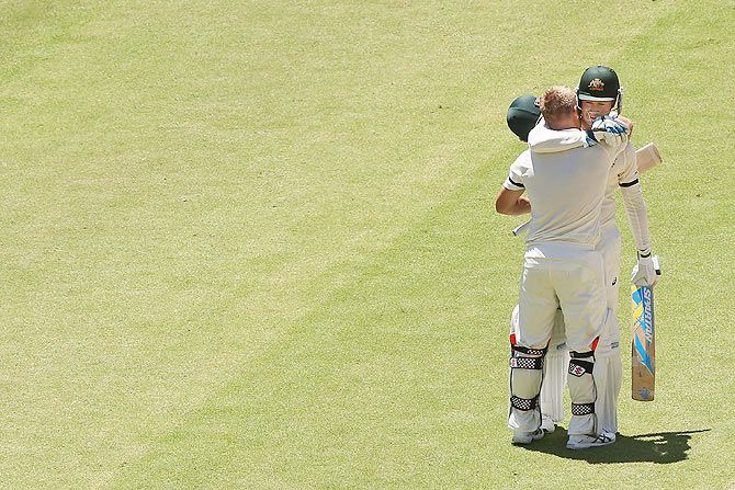 David Warner is hugged by captain Michael Clarke (right) after completing his century 