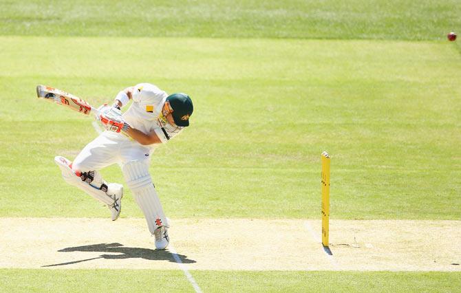 David Warner of Australia avoids a bouncer from Varun Aaron of India