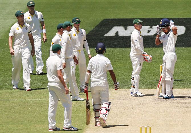 Australian players check on Virat Kohli after he was hit on the helmet by a Mitchell Johnson bouncer on Thursday